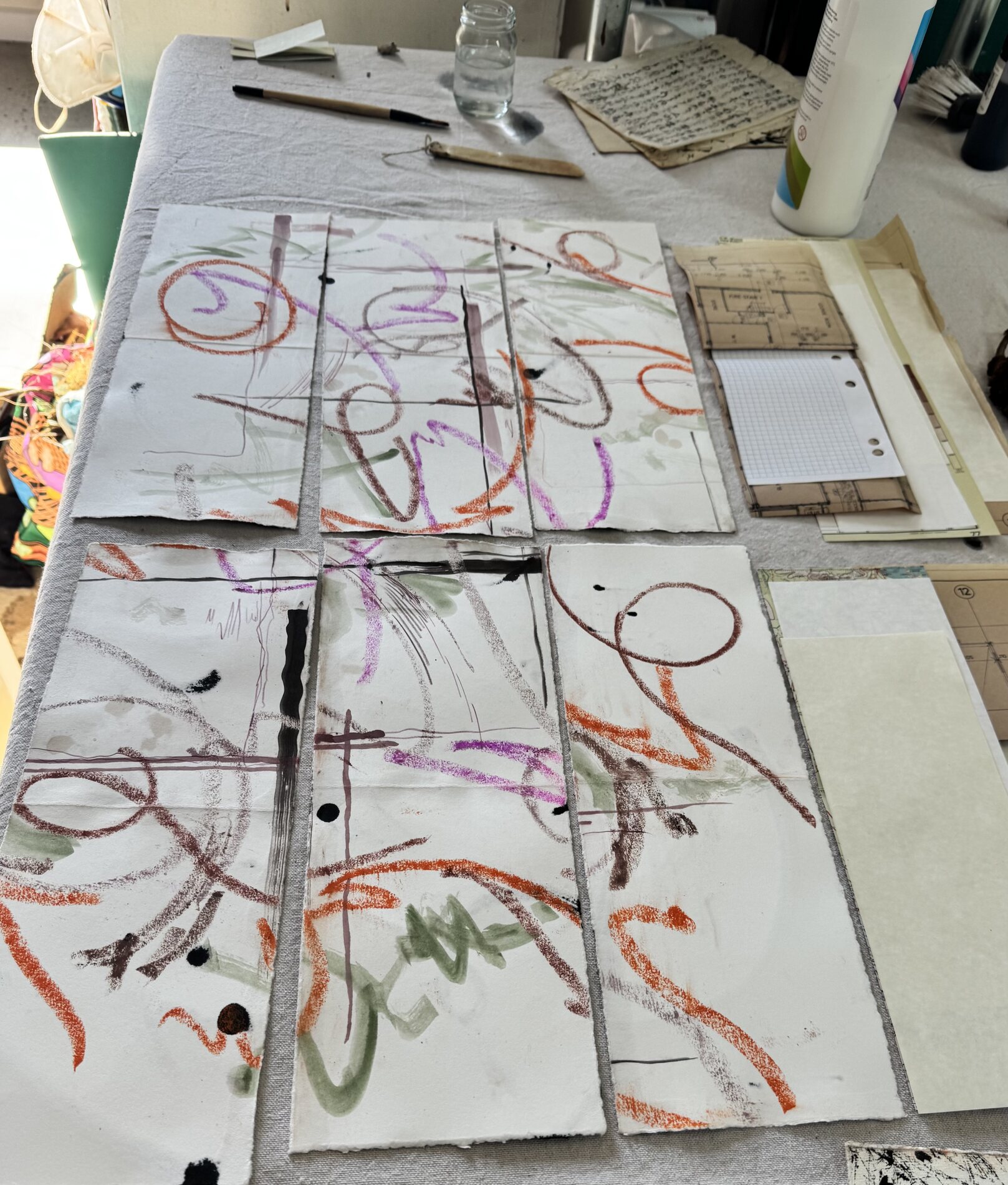 Student abstract studies on paper arranged in a grid with pastel, ink and watercolour marks